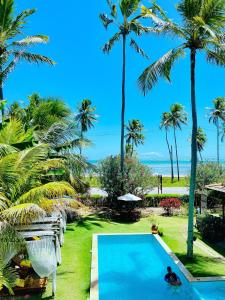 a view of the pool and beach from the resort at Pousada San Giovanni in Japaratinga