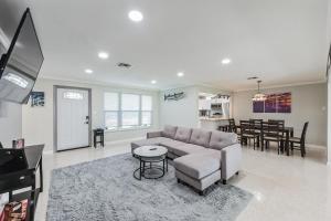 a living room with a couch and a table at Riverside Retreat: Deck Bar, FirePit, Boat Parking in Fort Myers