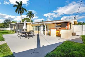 a patio with a table and chairs and a house at Riverside Retreat: Deck Bar, FirePit, Boat Parking in Fort Myers