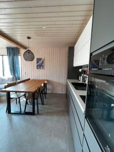 cocina con mesa de madera y comedor en Marina Villa, en Kõiguste