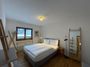 um pequeno quarto com uma cama e uma janela em Moderne Ferienwohnung mit Zugspitzblick em Grainau