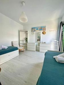 a white bedroom with two beds and a mirror at La dolce vita in Mala