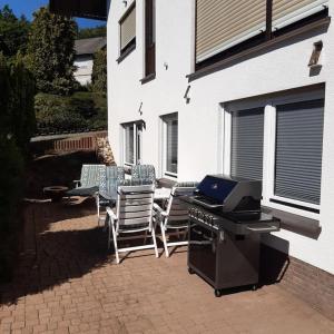 a patio with a grill and chairs and a table at FEWO Happe in Lennestadt