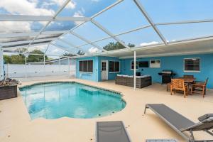 a swimming pool with a glass roof on a patio at Ocean Blue Heated Pool Home in Largo