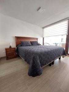 a bedroom with a large bed with a large window at Claro Centro Temuco in Temuco