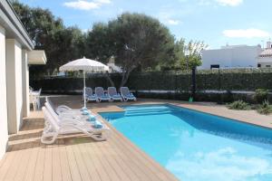 una piscina con 2 tumbonas y una sombrilla en Villa SONIA, en Cala en Blanes
