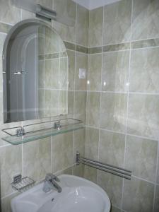 a bathroom with a sink and a mirror at BALATON ART Guesthouse in Balatonszemes