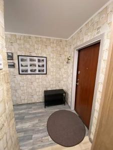 een kamer met een deur en een kleed naast een stenen muur bij Vieno kambario apartamentai 1 aukšte in Mažeikiai