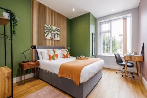 een slaapkamer met een groot bed met groene muren bij Sea Breeze - Coast in Bournemouth