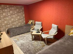 een slaapkamer met 2 bedden en een tafel en stoelen bij Vieno kambario apartamentai 1 aukšte in Mažeikiai
