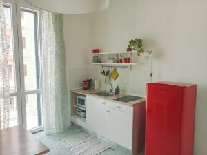a kitchen with a red refrigerator next to a window at La casa di Alessandro in Monopoli