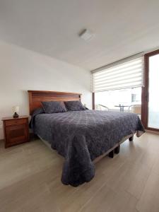 a bedroom with a large bed and a large window at Claro Centro Temuco in Temuco