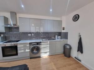 a kitchen with a washer and a sink and a dishwasher at 2 bedroom central apartment near station in London