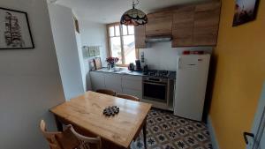 una pequeña cocina con mesa y nevera en Appartement en maison de ville, en Pontarlier