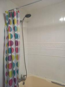 a shower curtain with a shower head in a bathroom at Cozy House, Garden, Free Parking, Opposite Train station with Disneyplus & Netflix included in West Thurrock