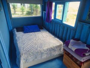 a small bedroom with a bed and a window at Casita de Mar in Cabo Polonio