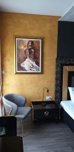 a bedroom with a bed and a desk and a painting at Apartmani President I in Banja Luka