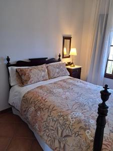 a bedroom with a bed and a lamp and a window at Casa rural Villa Manuela in Cazalla de la Sierra