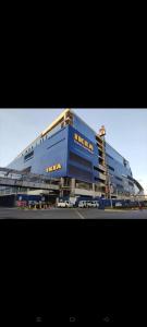 a large blue building with cars parked in front of it at Sea Residences, S, Shell Janine's Residency in Manila