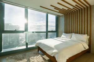 een slaapkamer met een bed en een groot raam bij Luxury 2BR Gem in One Uptown bgc in Manilla