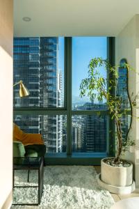 een woonkamer met een groot raam met een plant bij Luxury 2BR Gem in One Uptown bgc in Manilla