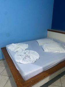 a bed with white sheets and towels on it at Hotel Angely in Belo Horizonte