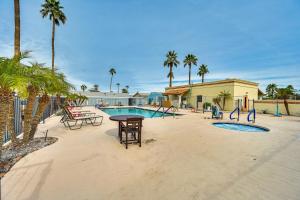 a pool with a playground with a table and chairs at Yuma Home with Fire Pit and Outdoor Community Pool! in Yuma