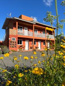ein Haus mit gelben Blumen davor in der Unterkunft Apartamentos de Altitude Urubici in Urubici