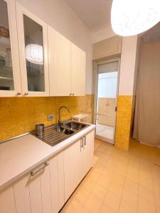 a kitchen with white cabinets and a sink at Trilo Stefano in residence con piscina, vicino al mare in Marcelli
