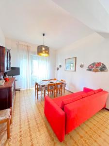 a living room with a red couch and a table at Trilo Stefano in residence con piscina, vicino al mare in Marcelli