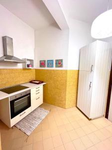 a kitchen with a stove and a refrigerator at Trilo Stefano in residence con piscina, vicino al mare in Marcelli +21 photos