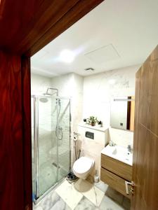 a bathroom with a shower and a toilet and a sink at 2BR Agadir Apartment with Pool and Netflix in Agadir