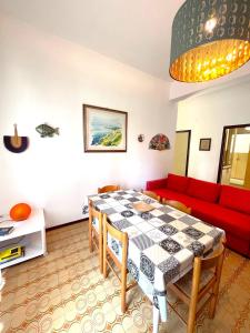 a living room with a table and a red couch at Trilo Stefano in residence con piscina, vicino al mare in Marcelli
