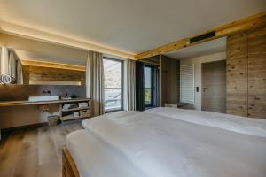 a bedroom with a large white bed and windows at WEIN DOMIZIL Zieger in Neuhaus am Klausenbach