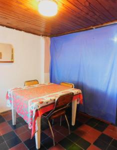 a table and chairs in a room with a blue curtain at Casa 3 ambientes hasta para 5 personas in Gualeguaychú