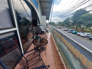 a balcony with tables and chairs on a building at Sleeping Mountain Arenal in Fortuna