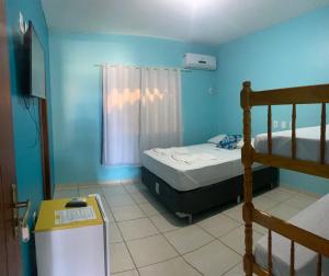 a small room with a bed and a bunk bed at Pousada e Restaurante Palomar in Ilhéus