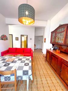 a living room with a red couch and a table at Trilo Stefano in residence con piscina, vicino al mare in Marcelli