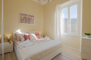 una camera da letto con un grande letto bianco e una finestra di [*ViLLA GiUSTi LiBERTY HOME*] SPA BBQ Wifi Parking a Lucca
