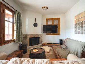 a living room with a couch and a tv at Traditional cosy chalet in Livadi in Kalívia