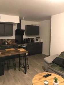 een woonkamer met een keuken met een bank en een tafel bij Élégant Appartement proche Commodités - Parfait pour Jeux Olympiques 2024 in Maurepas