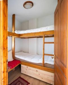 2 Etagenbetten in einem Zimmer mit einer Tür in der Unterkunft Traditional cosy chalet in Livadi in Kalívia