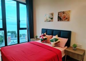 a bedroom with a red bed with a large window at Amazing Seaview 2 Bedroom Bathtub Georgetown 6-8people超级海景双房带浴缸高级公寓 in George Town