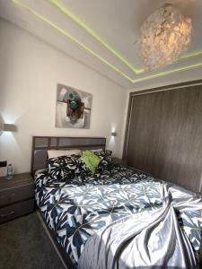 - une chambre avec un lit et un lustre dans l'établissement Ibtissam home, à Kenitra