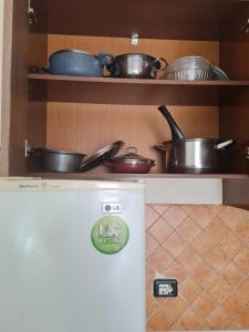 uma cozinha com panelas e frigideiras numa prateleira em Veri's house em Tirana