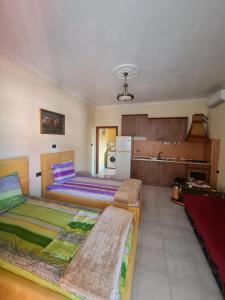 um quarto com 2 camas e uma cozinha com um frigorífico em Veri's house em Tirana