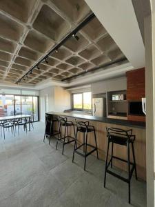 a room with a bar with stools in a kitchen at Apto com vista para Redenção ! in Porto Alegre