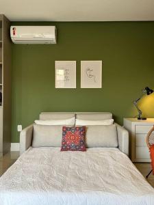 a bed in a room with a green wall at Apto com vista para Redenção ! in Porto Alegre