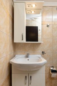 a bathroom with a white sink and a mirror at HOME WITH VIEW in Xanthi