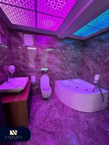 a purple bathroom with a tub and a toilet at X SAPANCA OTEL in Sakarya